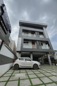 una macchina bianca parcheggiata di fronte a un edificio di Pepper coast suites a Cochin