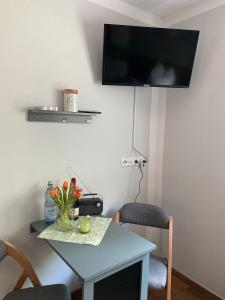 a room with a table and a tv on the wall at Zum Kölpiensee in Kolpinsee