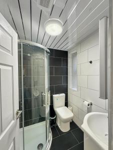 a bathroom with a toilet and a shower and a sink at Granada Apartments at Pleasure Beach in Blackpool +98 photos