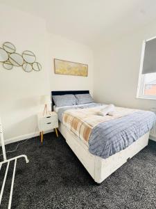 Un dormitorio con una cama grande en una habitación blanca. en Swanky Dudley Retreat, en Dudley