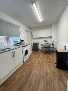 cocina con fregadero y mesa con lavadora en Swanky Dudley Retreat, en Dudley 14 fotos más