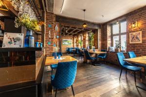 a restaurant with wooden tables and blue chairs at Hotel Artus - Old Town in Gdańsk