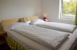 two beds with white sheets and a window in a bedroom at Rosenhof am Main in Offenbach