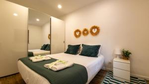 ein Schlafzimmer mit zwei Betten und einem Spiegel in der Unterkunft Casa Jasmim, Quinta Carmo - Alcobaça/Nazaré in Alcobaça + 31 Fotos