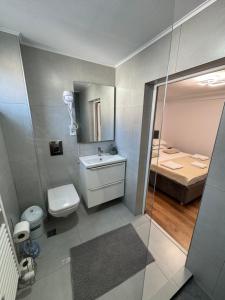 a bathroom with a sink and a toilet and a bed at Casa Luțea in Moieciu de Jos +17 photos