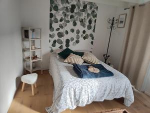 a bedroom with a bed with a blanket and a chair at Bienvenue Studio in Bouguenais