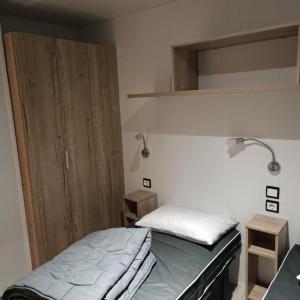 a bedroom with a bed with a lamp and a closet at Les Ch'tis Normands ! 2 hébergements au choix in Litteau +45 photos