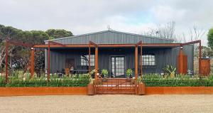 潘尼萧The Rusty Kangaroo - 2 Premium Couples Retreats - Spectacular Ocean View - Great Hosts的前面有围栏的小房子