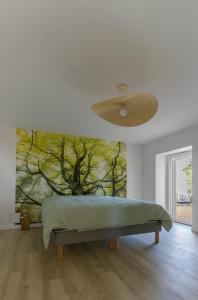 a bedroom with a bed with a painting on the wall at Résidence Penaud - Appartements design et climatisés à la campagne in Saulcet +61 photos