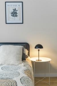 ein Schlafzimmer mit einem Bett und einem Tisch mit einer Lampe in der Unterkunft Résidence Louis B - Appartements design et climatisés in Vichy