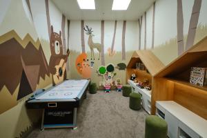 a childs room with a mural of a forest at Sheraton Astana Hotel in Astana