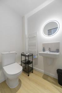 a bathroom with a toilet and a sink at Résidence Louis B - Appartements design et climatisés in Vichy