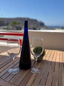 a bottle of wine and two glasses on a table at Apartamento Victoria in Mogán