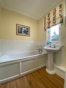 a bathroom with a bath tub and a sink at Lochs Lodge, Glenlyon, Perthshire in Bridge of Balgie