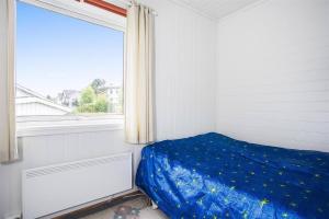 a bedroom with a blue bed and a window at Cozy Private apartment in the Heart of the city in Kystad