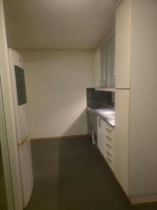 a small kitchen with white appliances and a refrigerator at Cozy Private apartment in the Heart of the city in Kystad