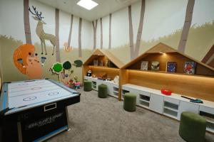 a play room with a ping pong table in a forest at Sheraton Astana Hotel in Astana