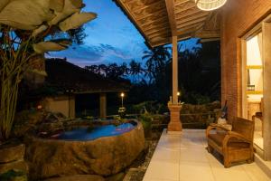 a garden with a jacuzzi tub in a yard at Kresna Asih House in Tampaksiring