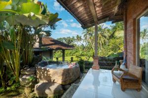 a garden with a large stone tub in a yard at Kresna Asih House in Tampaksiring