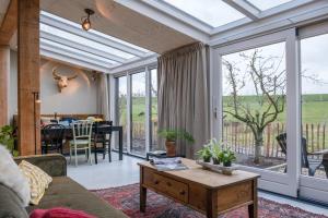 a conservatory living room with a couch and a table at Logement de Appelgaard in Culemborg