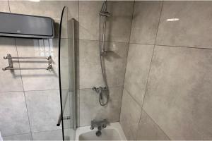 a shower with a glass door next to a toilet at Apartment - Sleeps 4 - City Base - District Line in Dagenham Dock