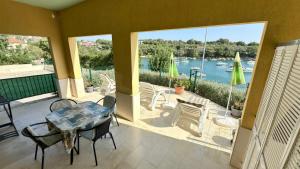 a patio with a table and chairs and a view of the water at VILLAMAR beachfront apartments with FREE private parking in Rabac