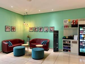 a store with two couches and two tables and chairs at Garner Hotel Cottbus Süd by IHG in Cottbus