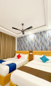 um quarto com duas camas e um ventilador de teto em Priya Residency Pondicherry em Pondicherry