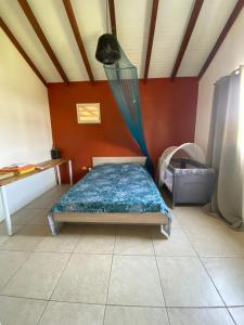 a bedroom with a bed with a mosquito net at Villa Surf Kreol moderne à 3 min du Souffleur in Port-Louis