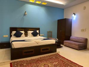 a bedroom with a king sized bed and a chair at Airport Hotel Annexe, Complimentory Pickup or Drop in New Delhi +18 photos