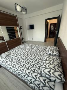 ein Schlafzimmer mit einem Bett mit einer schwarz-weißen Bettdecke in der Unterkunft Militari Confort Suites in Roşu