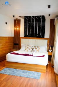 een slaapkamer met een groot wit bed in een kamer bij Mayooram cruises -luxury houseboat in Alleppey