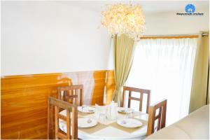 een eettafel met stoelen en een kroonluchter bij Mayooram cruises -luxury houseboat in Alleppey