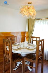 een eettafel met stoelen en een kroonluchter bij Mayooram cruises -luxury houseboat in Alleppey