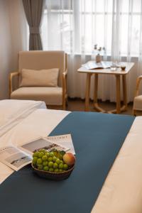 a basket of fruit sitting on top of a bed at Serene Clouds And Moonlight in Dali