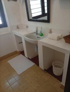 une salle de bain avec un lavabo et un miroir dans l'établissement Boma Banda Diani - Kaskazi Cottage, à Diani Beach