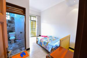 a bedroom with a bed and a bathroom with a shower at Guadalupe house in Masaka