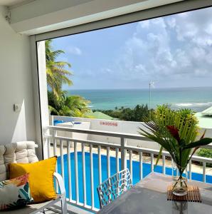 a balcony with a table and a view of the ocean at Le 35 Anse des Rochers Saint-François in Saint-François
