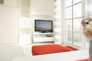 a living room with a television and a red ottoman at Happy Place in Bojendorf