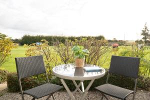 a table with two chairs and a table with a plant at Happy Place in Bojendorf +20 photos