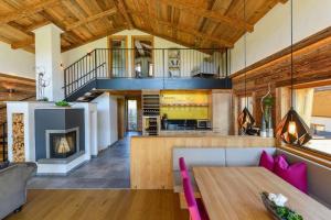 a living room with a table and a fireplace at Gams Lodge in Enkerbichl