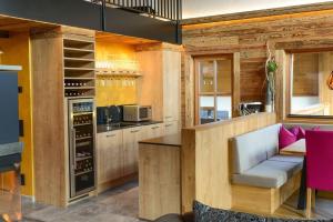 a kitchen with wooden walls and a bar with a white chair at Gams Lodge in Enkerbichl