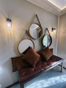 a brown couch with two mirrors on a wall at Koliba 22 in Bratislava
