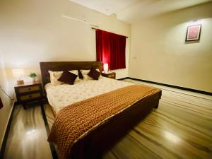 a bedroom with a bed and a red window at Sowkya Stays, Kakinada - Service Apartment, Home Stay, Vididhillu in Kākināda