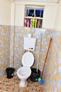 ein Bad mit WC in einem gefliesten Zimmer in der Unterkunft Studio bnb by Tsparks in Gatunga