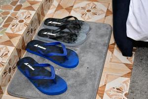 Ein Paar blaue Sandalen steht auf dem Boden in der Unterkunft Studio bnb by Tsparks in Gatunga