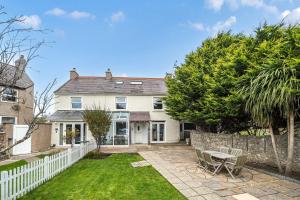 an exterior view of a house with a white fence at Ty Mawr, Great Orme in Llandudno