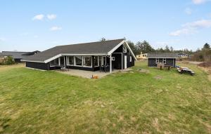 una gran casa negra con un gran patio de césped en Cozy Home In Løgstør With Sauna, en Trend 17 fotos más