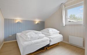 Dos camas en una habitación pequeña con ventana. en Cozy Home In Løgstør With Sauna, en Trend
