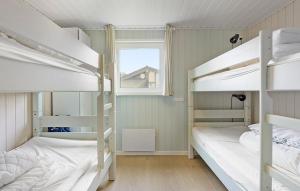 Dos literas en una habitación con ventana. en Cozy Home In Løgstør With Sauna, en Trend